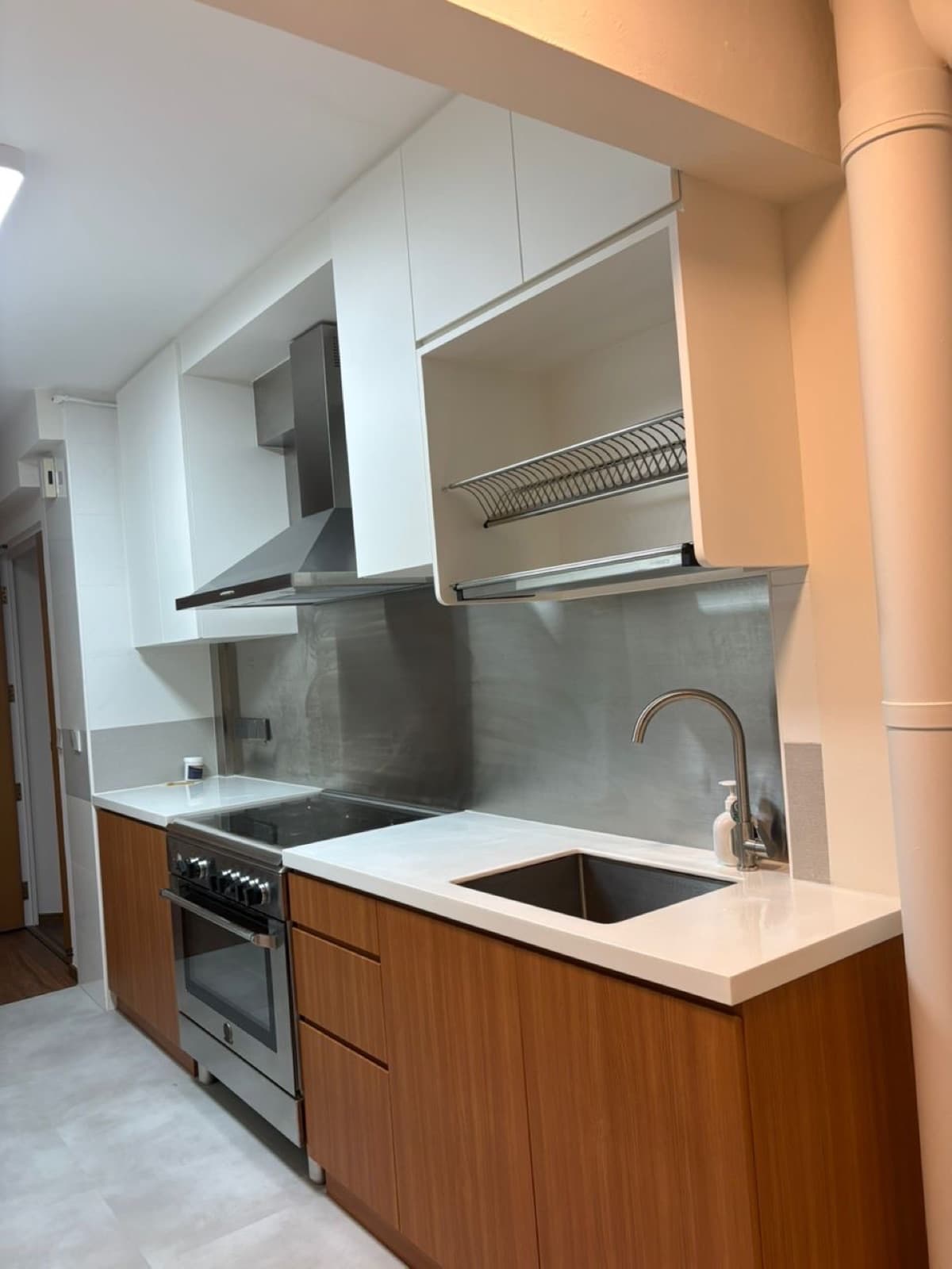 Kitchen cabinets wrapped in white and warm walnut wood-grain